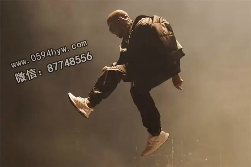 Kanye West performing at the 2015 Billboard Music Awards, wearing Triple White adidas Ultraboost sneakers.